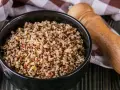 Un bol de quinoa, un aliment polyvalent, est-il un féculent ou une légumineuse ? Servi avec une serviette à carreaux et un moulin à poivre en bois.