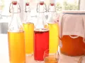 Bouteilles de kombucha jaune et rouge, prêtes pour la fermentation. Apprenez comment faire du kombucha maison.