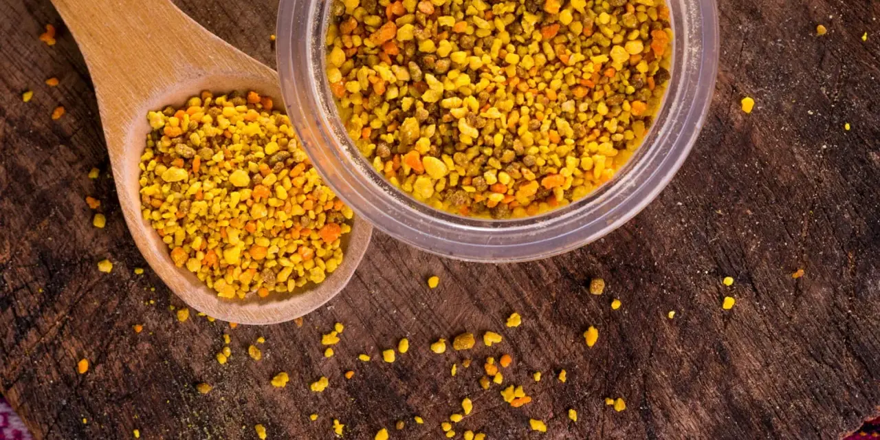 Une cuillère en bois et un pot remplis de pollen d'abeille, un concentré de bienfaits naturels.