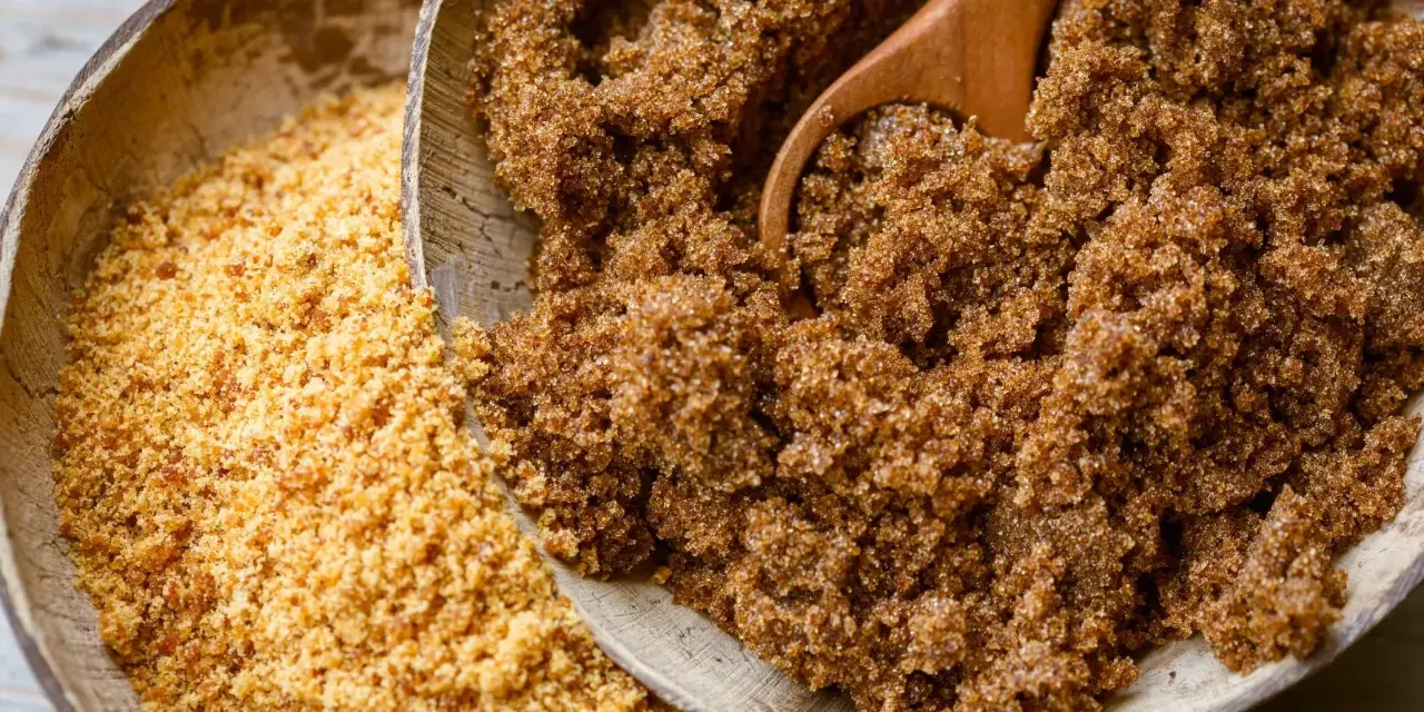 Deux bols en bois remplis de sucre : l'un de rapadura, l'autre de sucre de coco.