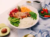 Un bol coloré avec du poulet grillé, du riz, des légumes frais et des épices. Une recette healthy parfaite pour un repas équilibré.