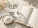 Poudre de collagène marin, verre d'eau, carnet ouvert et icônes de santé. Réflexion sur les dangers potentiels du collagène marin.