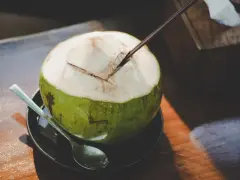 Une noix de coco fraîchement ouverte, prête à être dégustée. L'eau de coco, promesse d'une hydratation pure, est un délice qui ne trompe jamais.