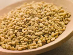 Graines de fenugrec sur une cuillère en bois, une aide naturelle pour gérer l'hypertension.