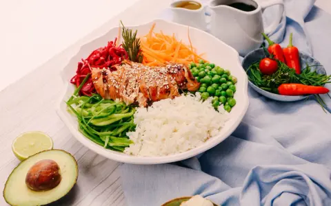 Un bol coloré avec du poulet grillé, du riz, des légumes frais et des épices. Une recette healthy parfaite pour un repas équilibré.