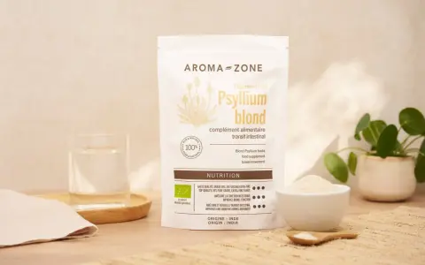 Un sachet de téguments de psyllium blond Aroma-Zone, un verre d'eau et une coupelle de poudre. Idéal pour le transit intestinal.