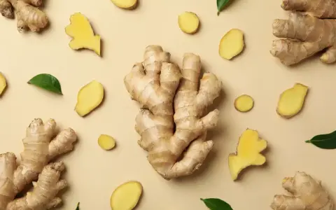Gingembre frais, en morceaux et en tranches, disposés sur fond beige. Un aperçu de son gingembre effet immédiat.