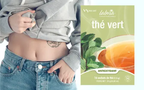 Une personne montre son ventre plat, suggérant la perte de poids, à côté d'une boîte de thé vert antioxydant.