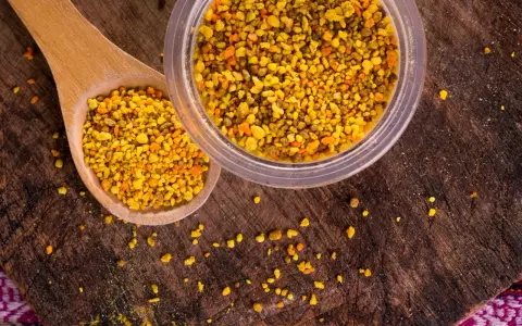 Une cuillère en bois et un pot remplis de pollen d'abeille, un concentré de bienfaits naturels.