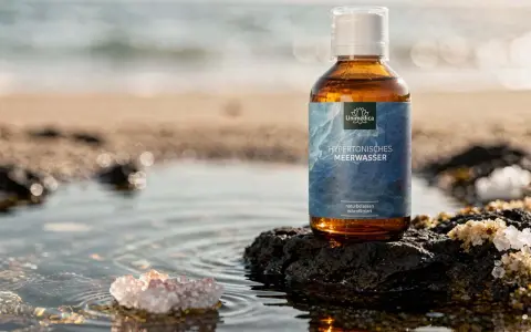 Bouteille d'eau de Quinton sur un rocher, évoquant le bien-être des intestins et la pureté de l'océan.