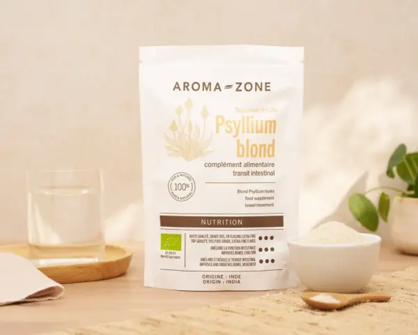 Un sachet de téguments de psyllium blond Aroma-Zone, un verre d'eau et une coupelle de poudre. Idéal pour le transit intestinal.