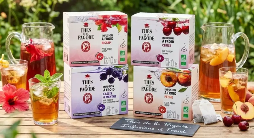 Quatre boîtes de "Thés de la Pagode" : infusions à froid Bissap, Cerise, Cassis & Menthe, et Pêche. Des carafes et verres de boissons glacées complètent la scène.