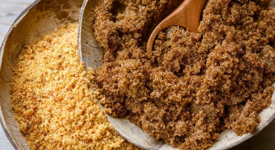 Deux bols en bois remplis de sucre : l'un de rapadura, l'autre de sucre de coco.