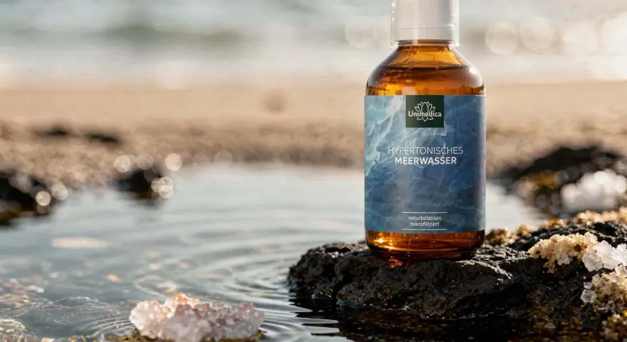 Bouteille d'eau de Quinton sur un rocher, évoquant le bien-être des intestins et la pureté de l'océan.