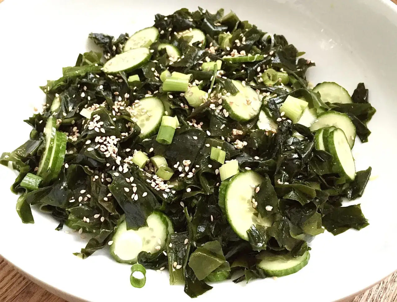 Salade fra&icirc;che de wakame algue, concombre et s&eacute;same, servie dans un bol blanc.