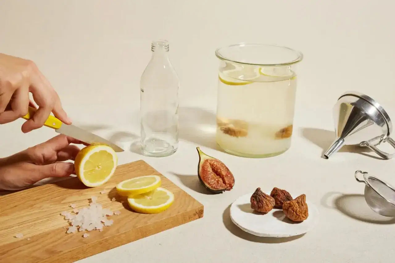 Pr&eacute;paration du k&eacute;fir : on coupe un citron, des figues s&eacute;ch&eacute;es et fra&icirc;ches sont &agrave; c&ocirc;t&eacute; d'un bocal de k&eacute;fir et d'une passoire.