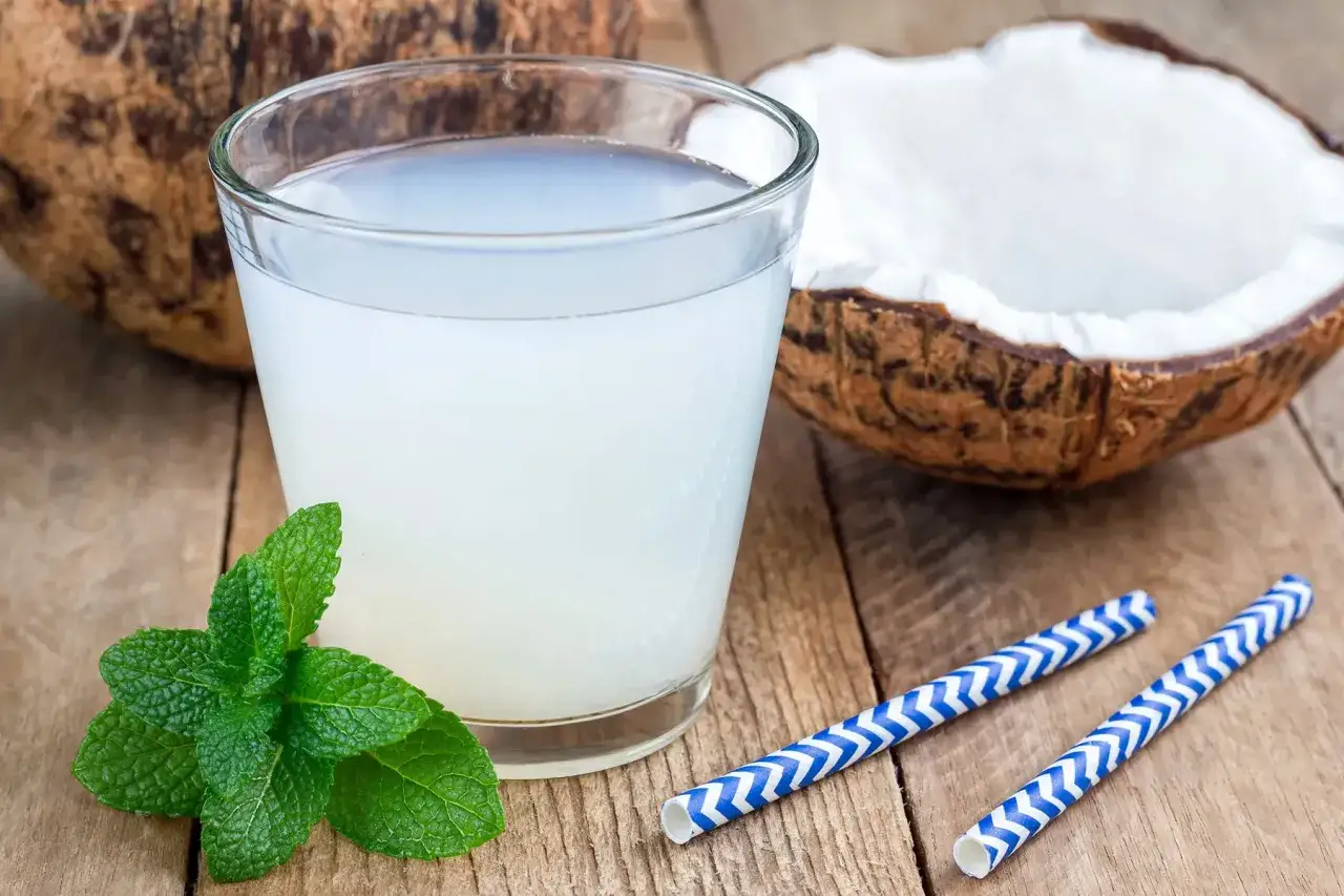 Verre d'eau de coco fra&icirc;che, menthe et pailles bleues. Une solution naturelle pour soulager la constipation.