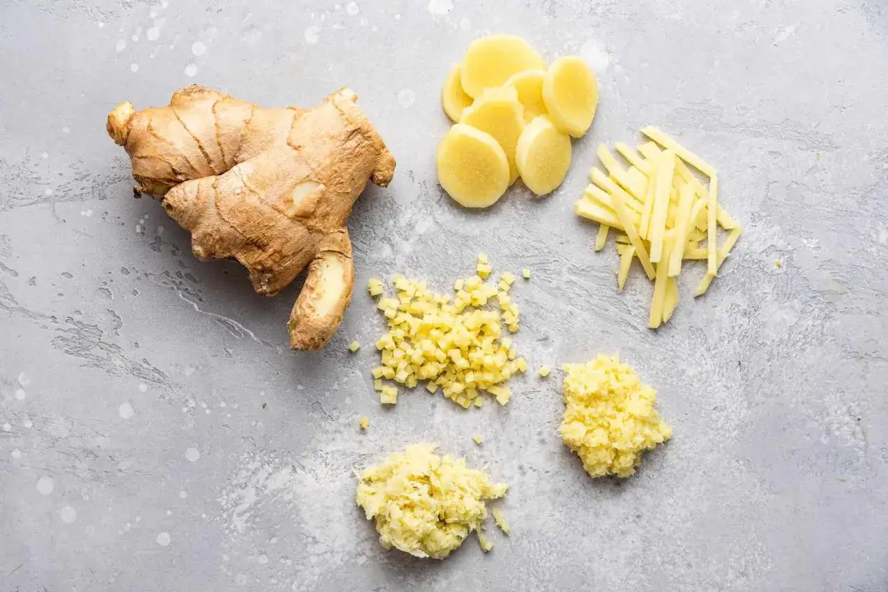 Un gros morceau de gingembre frais est pr&eacute;sent&eacute; &agrave; c&ocirc;t&eacute; de diff&eacute;rentes coupes : en rondelles, en julienne, en d&eacute;s et r&acirc;p&eacute;.